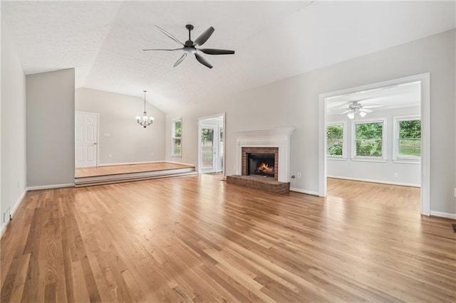 2655 Nesbit Trl, Alpharetta, GA 30022 - unfurnished living room with a chandelier, light wood-style floors, a brick fireplace, ceiling fan, and vaulted ceiling