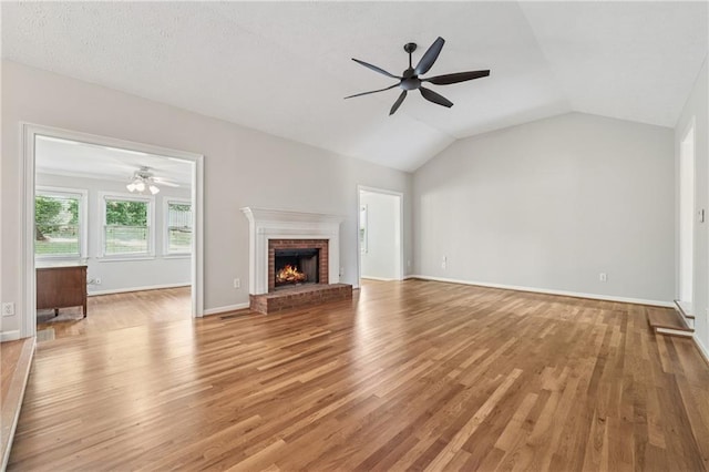 2655 Nesbit Trl, Alpharetta, GA 30022 - unfurnished living room with ceiling fan, light wood finished floors, a brick fireplace, and vaulted ceiling