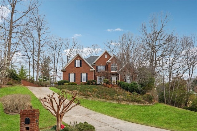 traditional-style home with brick siding, concrete driveway, and a front lawn