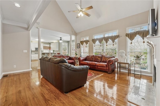 living room with visible vents, ornate columns, high vaulted ceiling, ceiling fan, and light wood-type flooring