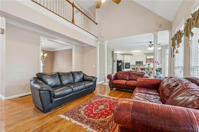 living room featuring decorative columns, a ceiling fan, and light wood-style floors