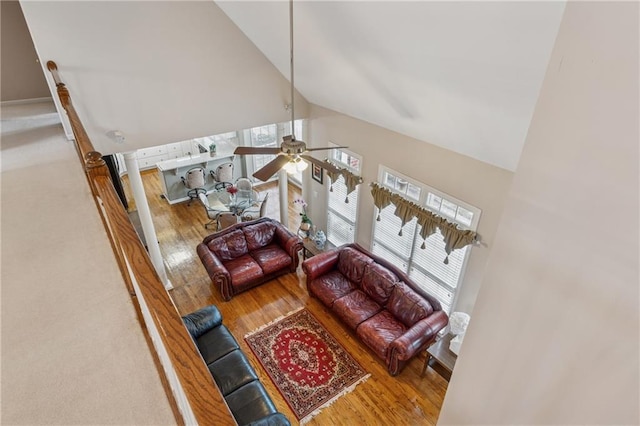 living area featuring high vaulted ceiling, ceiling fan, and wood finished floors