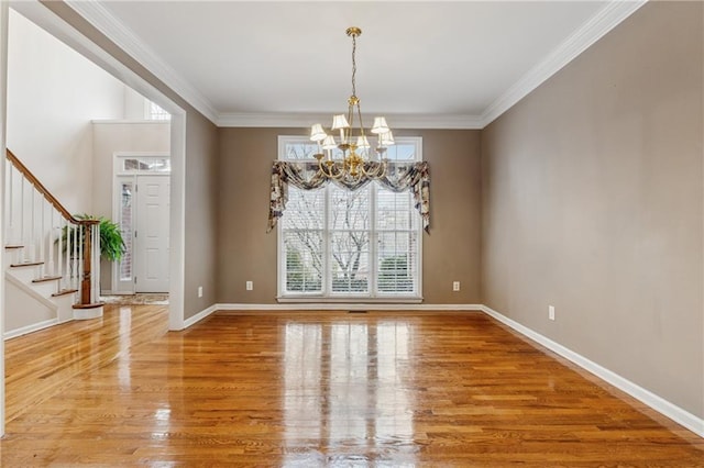 unfurnished room with stairway, light wood-style floors, a chandelier, and ornamental molding