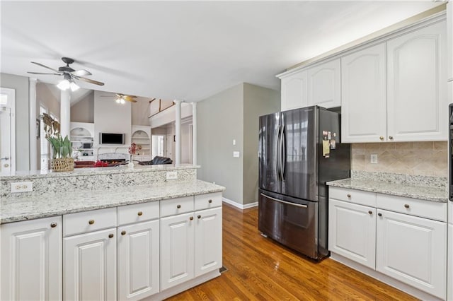 kitchen featuring wood finished floors, freestanding refrigerator, ceiling fan, decorative backsplash, and vaulted ceiling