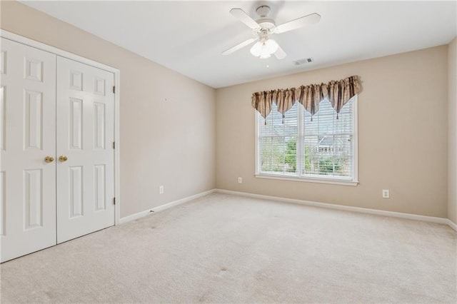 spare room featuring visible vents, baseboards, ceiling fan, and carpet floors