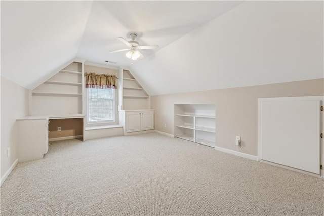 bonus room with baseboards, carpet, ceiling fan, built in features, and lofted ceiling