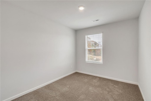 carpeted empty room featuring baseboards and visible vents