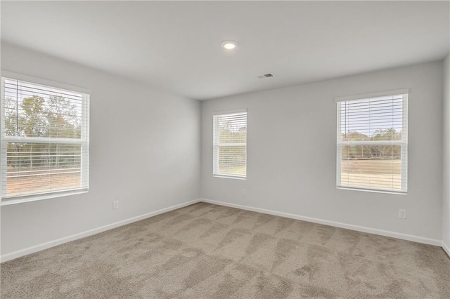 carpeted empty room with visible vents, recessed lighting, and baseboards