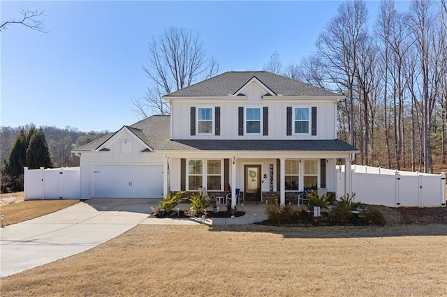 traditional-style home featuring fence, a porch, driveway, and a gate