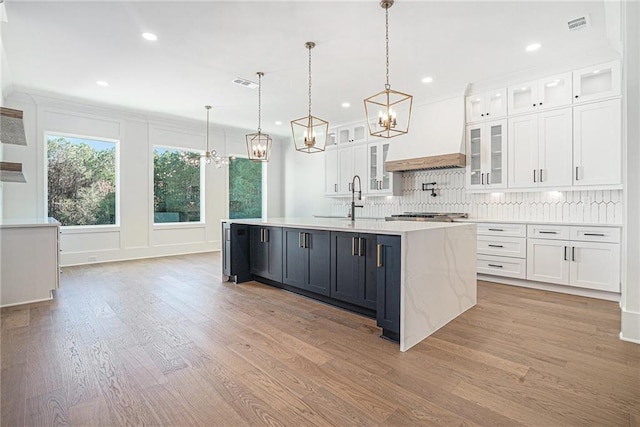kitchen with visible vents, white cabinetry, a chandelier, and light wood-type flooring