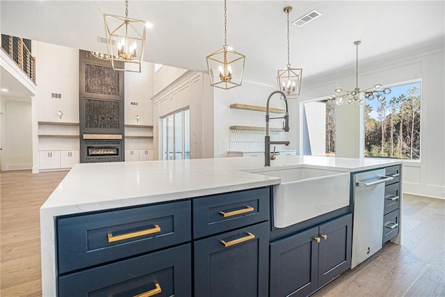 kitchen featuring a chandelier, visible vents, light wood-style floors, and a sink