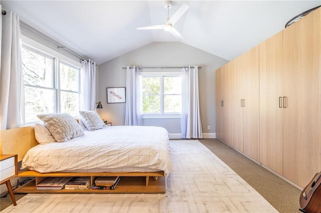 bedroom featuring lofted ceiling, light carpet, and a ceiling fan