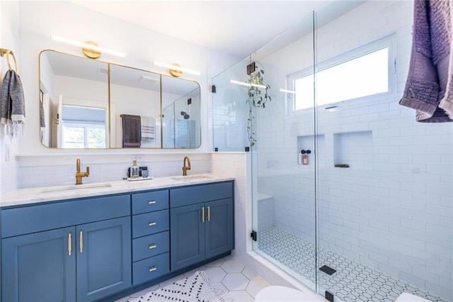 bathroom with a stall shower, a sink, and a wealth of natural light