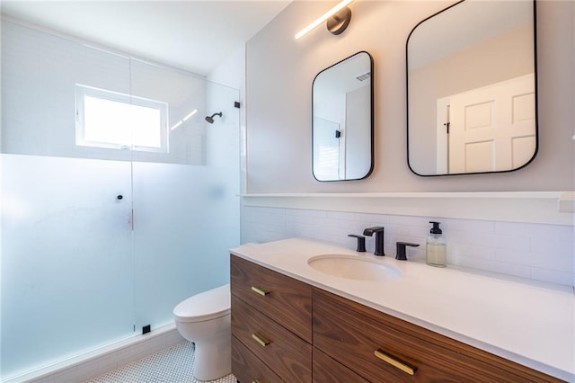 bathroom featuring vanity, a shower stall, toilet, and decorative backsplash