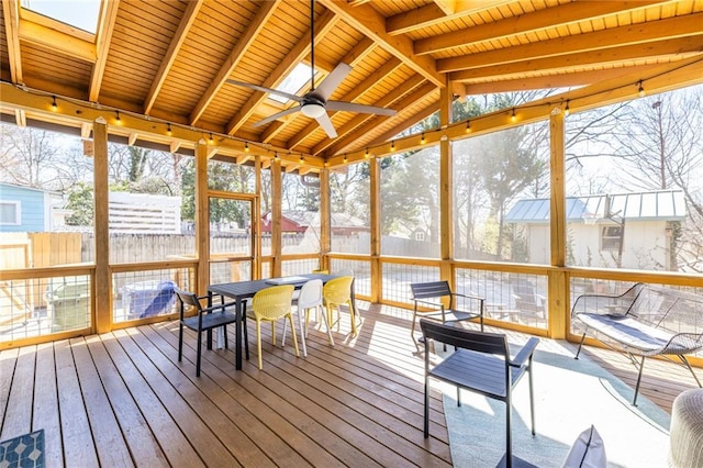 unfurnished sunroom with lofted ceiling with skylight, wood ceiling, and ceiling fan