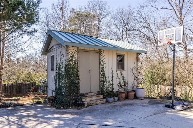 view of outbuilding featuring fence and an outbuilding