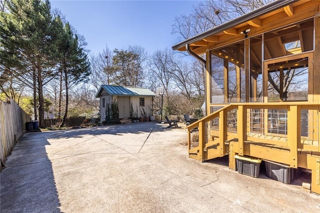 exterior space with a patio area, fence, and an outbuilding