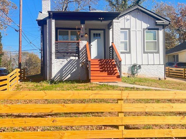 view of front of property featuring board and batten siding, fence, and a chimney