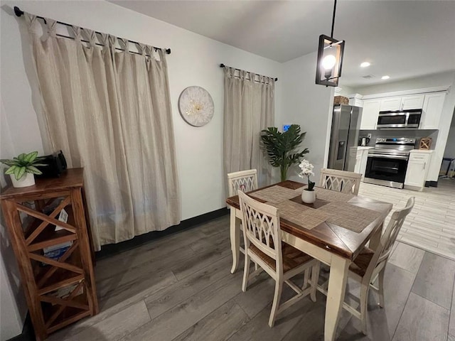 dining room featuring recessed lighting, dark wood finished floors, and baseboards