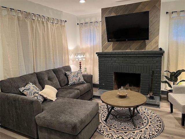 living area with a fireplace, wood finished floors, and recessed lighting