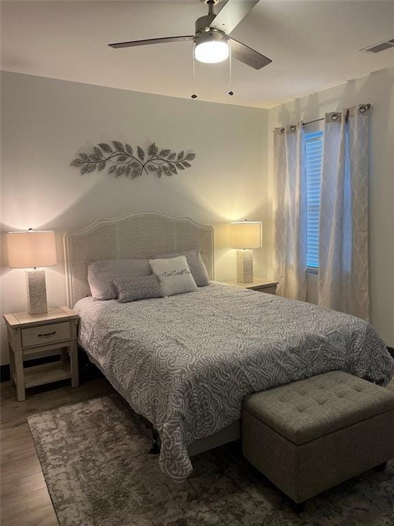 bedroom featuring ceiling fan, wood finished floors, and visible vents