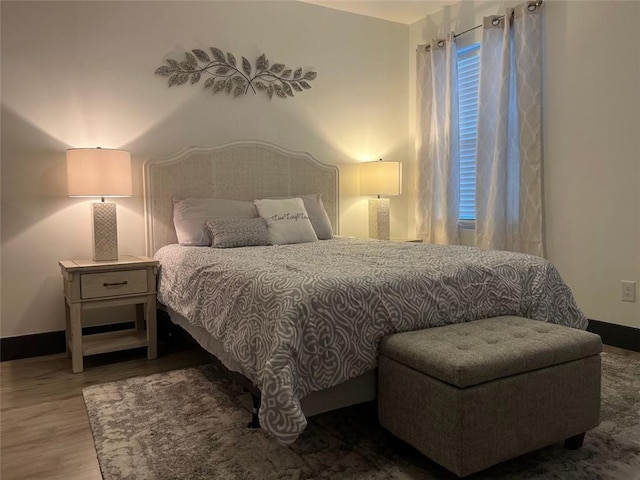 bedroom with baseboards and wood finished floors