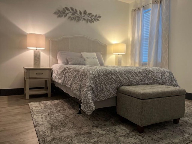 bedroom with baseboards and wood finished floors