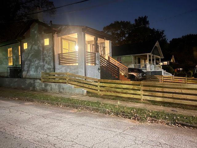 property exterior at twilight featuring a fenced front yard