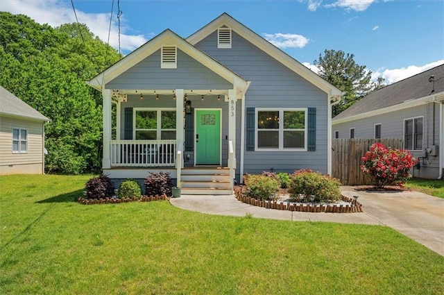 bungalow with a porch and a front lawn