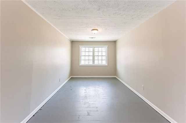 unfurnished room with visible vents, concrete floors, baseboards, and a textured ceiling