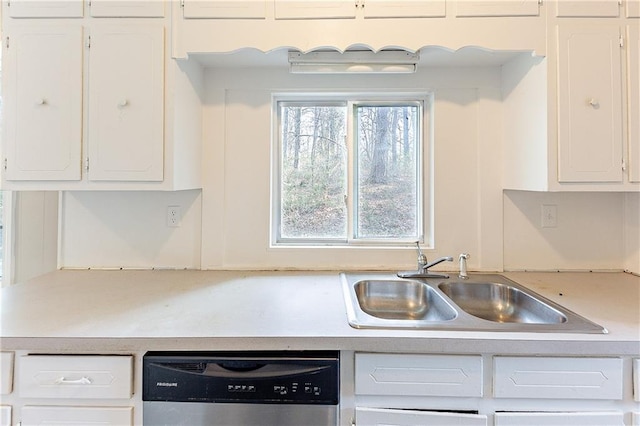 kitchen featuring dishwasher, a sink, and white cabinetry