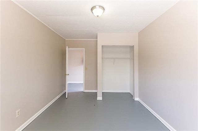 unfurnished bedroom featuring a closet, baseboards, and concrete flooring