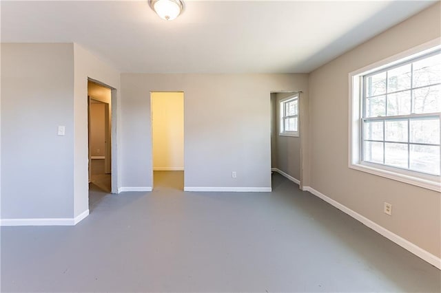 unfurnished bedroom featuring finished concrete flooring and baseboards