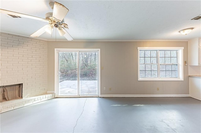 empty room featuring a textured ceiling, a brick fireplace, visible vents, and finished concrete floors