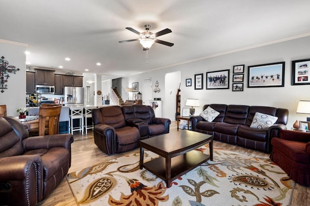 living room featuring recessed lighting, a ceiling fan, light wood-style floors, stairs, and ornamental molding