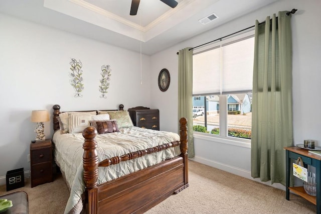 bedroom featuring light carpet, visible vents, baseboards, ornamental molding, and a raised ceiling