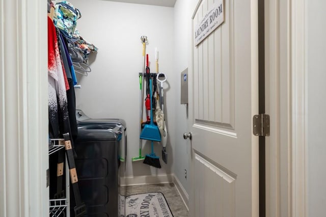 clothes washing area featuring laundry area, washing machine and dryer, and baseboards