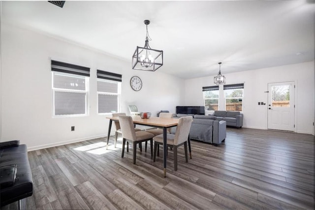 155 Knightsbridge Ln, Winder, GA 30680 - dining area featuring a chandelier, dark wood-type flooring, and baseboards