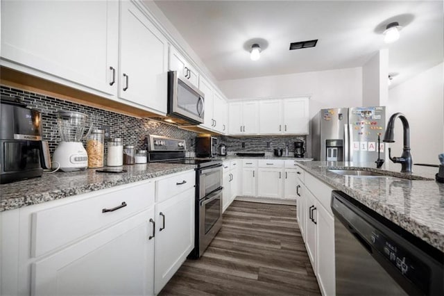 155 Knightsbridge Ln, Winder, GA 30680 - kitchen featuring stainless steel appliances, a sink, dark wood-style flooring, and light stone countertops