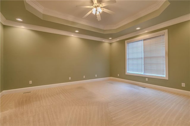 spare room featuring light carpet, a raised ceiling, ceiling fan, and ornamental molding