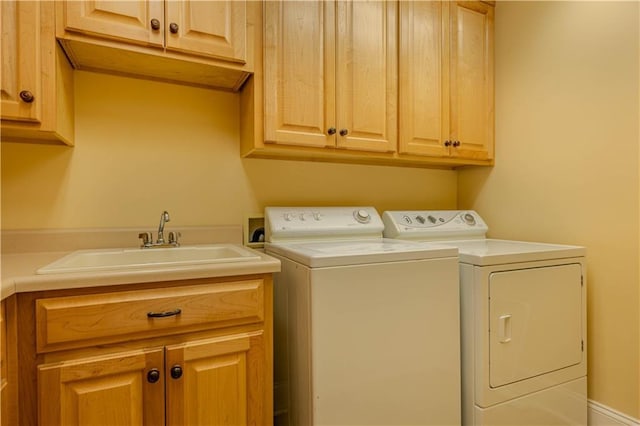 laundry area with washer and clothes dryer, cabinets, and sink