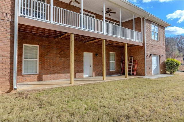 back of property with a yard, a deck, and ceiling fan