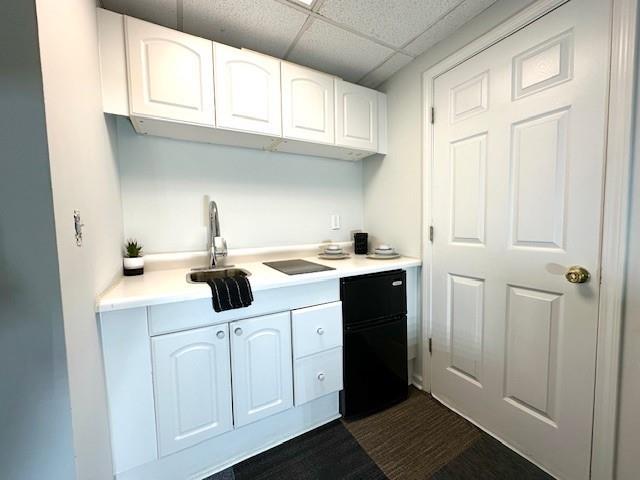942 Batesville Rd, Canton, GA 30115 - kitchen with white cabinets, a paneled ceiling, light countertops, dark wood-style floors, and a sink