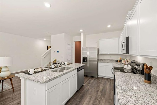 1315 Aura Ln, Lawrenceville, GA 30045 - kitchen with appliances with stainless steel finishes, a center island with sink, dark wood finished floors, white cabinets, and light stone countertops