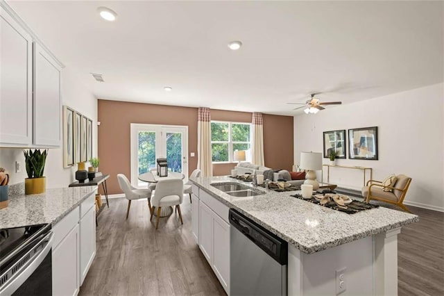 1315 Aura Ln, Lawrenceville, GA 30045 - kitchen with stainless steel appliances, white cabinetry, open floor plan, a kitchen island with sink, and wood finished floors
