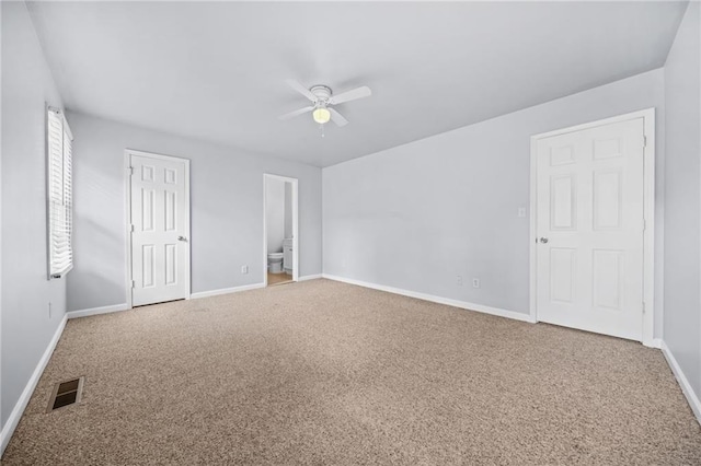 unfurnished bedroom with ensuite bath, carpet floors, and ceiling fan