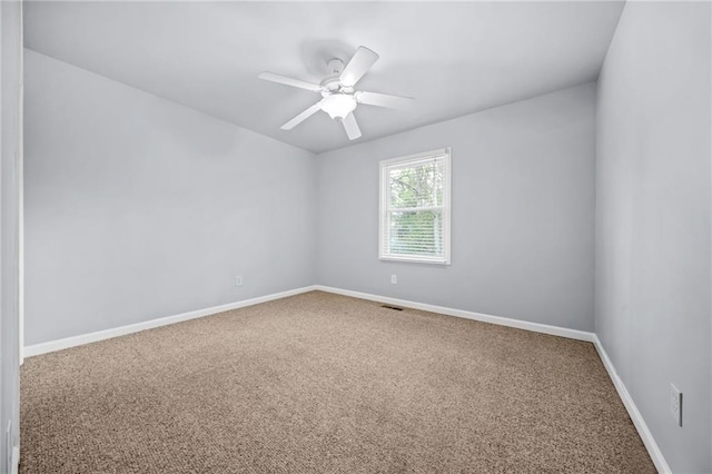 carpeted spare room with ceiling fan