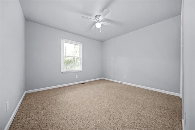 carpeted spare room with ceiling fan