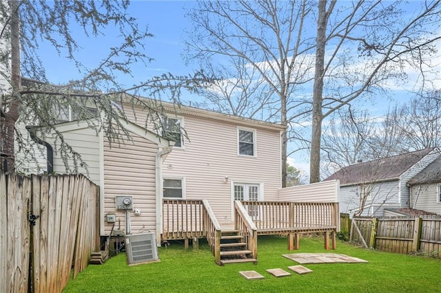 back of house featuring a wooden deck, central AC unit, and a lawn