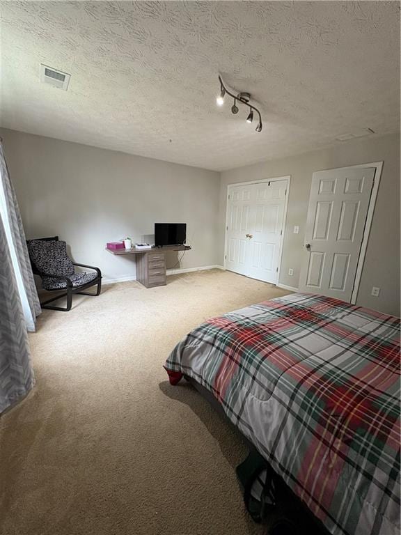carpeted bedroom featuring baseboards and a textured ceiling